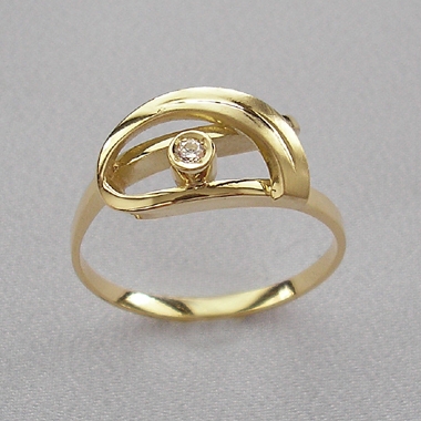 Prsten netradičního tvaru ze žlutého zlata zdobený menším vsazeným diamantem.