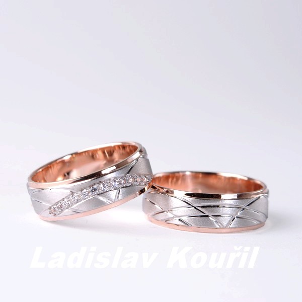 Snubní prsteny ve dvou barvách podle představ zákazníka. Drážky jsou nepravidelně rozmístěny do moderního designu. Prsteny jsou dvouvrstvé v dámském provedení doplněny kameny.